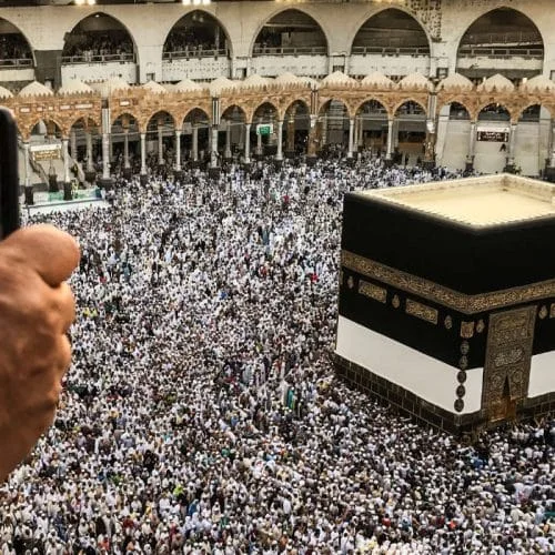 Seseorang guna telefon di hadapan Kaabah
