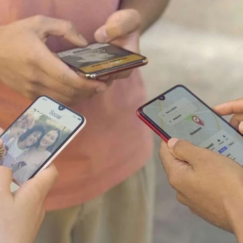Tiga orang sedang bermain telefon